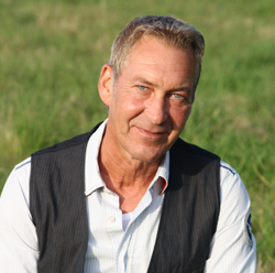 Porträt von Jörg Giese vor einer grünen Wiese